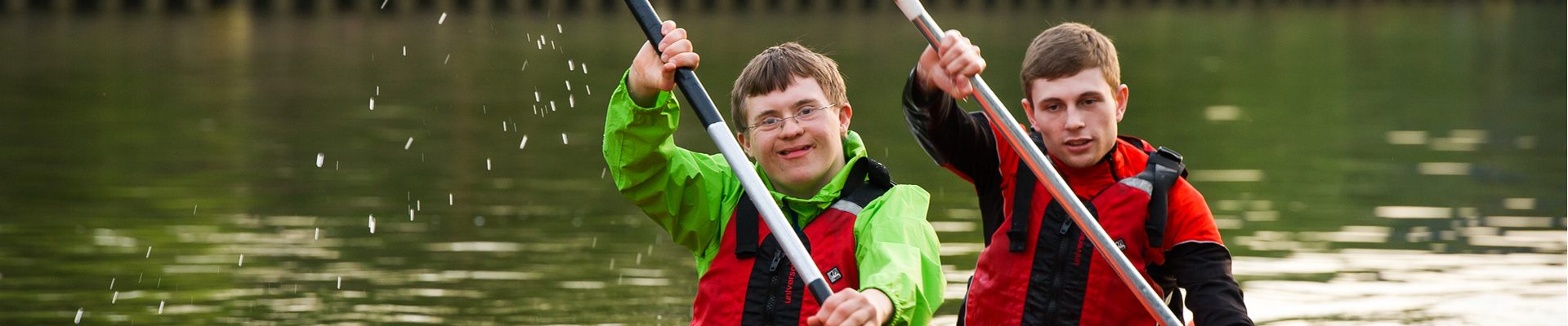 Headerbild Inklusion im Sport: Behinderter und Nicht-Behinderter paddeln gemeinsam in einem Boot