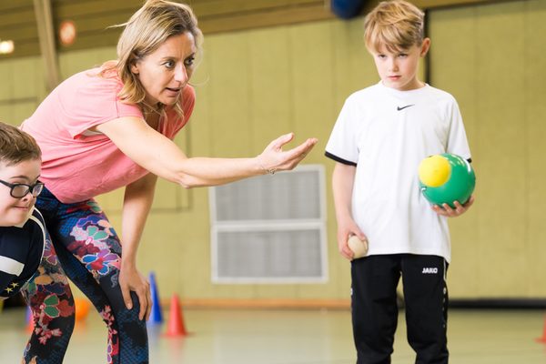 Übungsleiterin mit zwei Kindern in der Halle