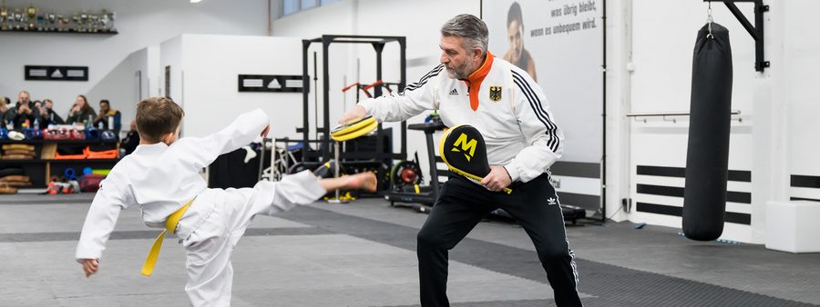 Symbolbild: Nachwuchs-Trainer mit jungem Sportler