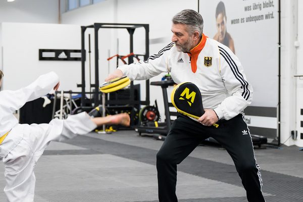 Symbolbild: Nachwuchs-Trainer mit jungem Sportler