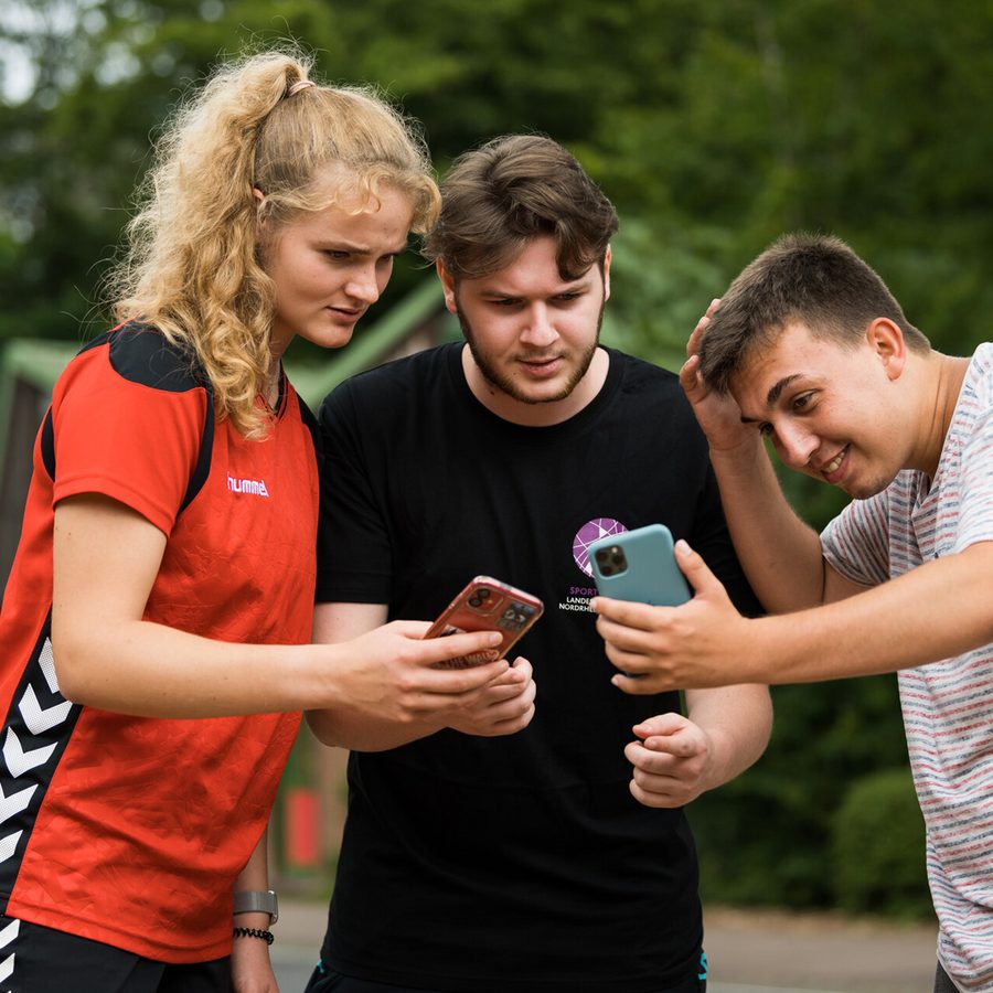 Jugendliche schauen aufs Smartphone