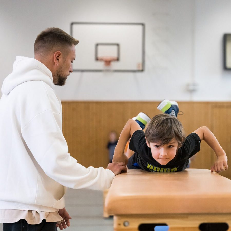 Lehrer mit Kind im SPortunterricht