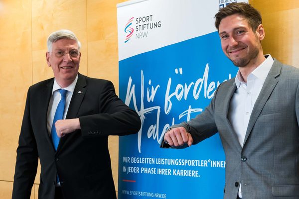 Zwei Männer stehen vor einem Rollup