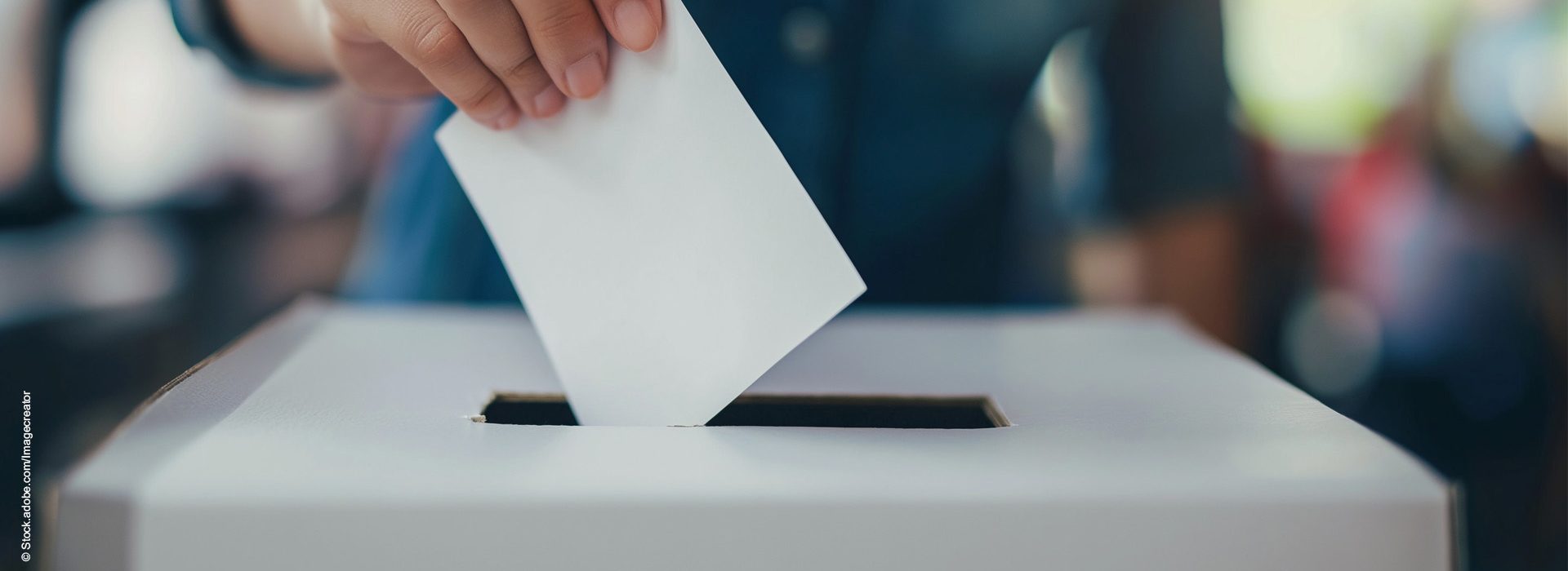 Hand wirft Wahlzettel in Wahlurne