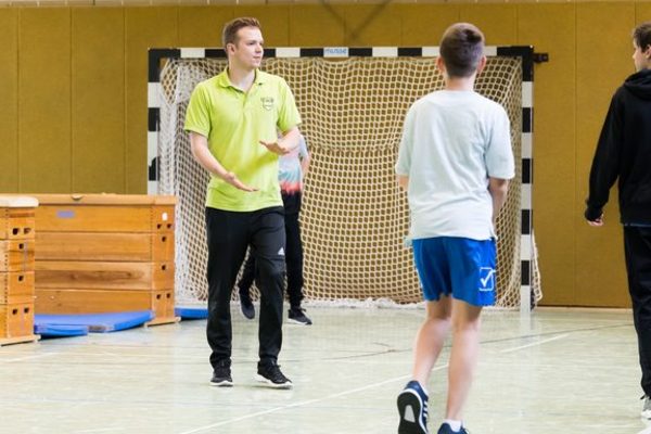 Übungsleiter mit Jugendlichen in der Halle