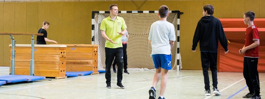Übungsleiter mit Jugendlichen in der Halle