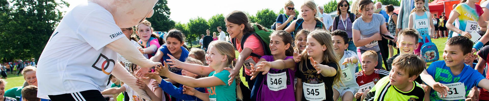 Headerbild Sportabzeichen: Kinder begrüßen beim Sportabzeichen-Tag in Xanten den Trimmy