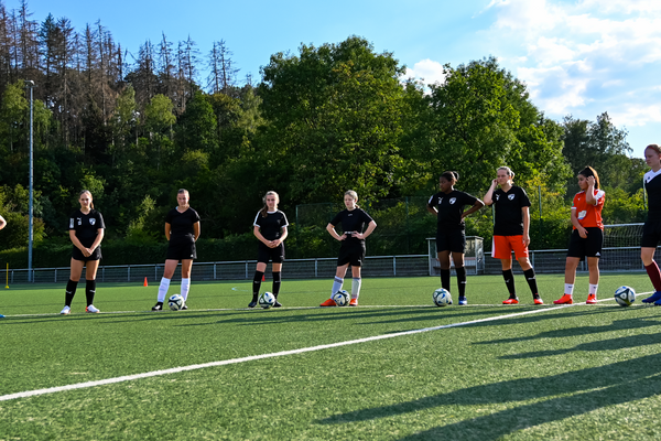 Symbolbild: Teambesprechung mit den Trainern auf dem Sportplatz