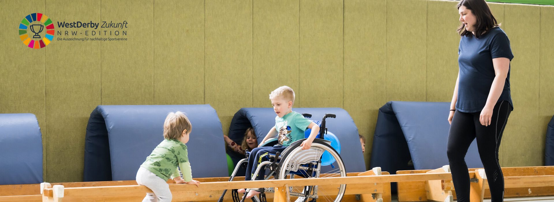 Übungsleiterin in Sporthalle mit Kindern mit und ohne Behinderung
