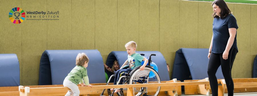 Übungsleiterin in Sporthalle mit Kindern mit und ohne Behinderung (Symbolbild für soziale Verantwortung)