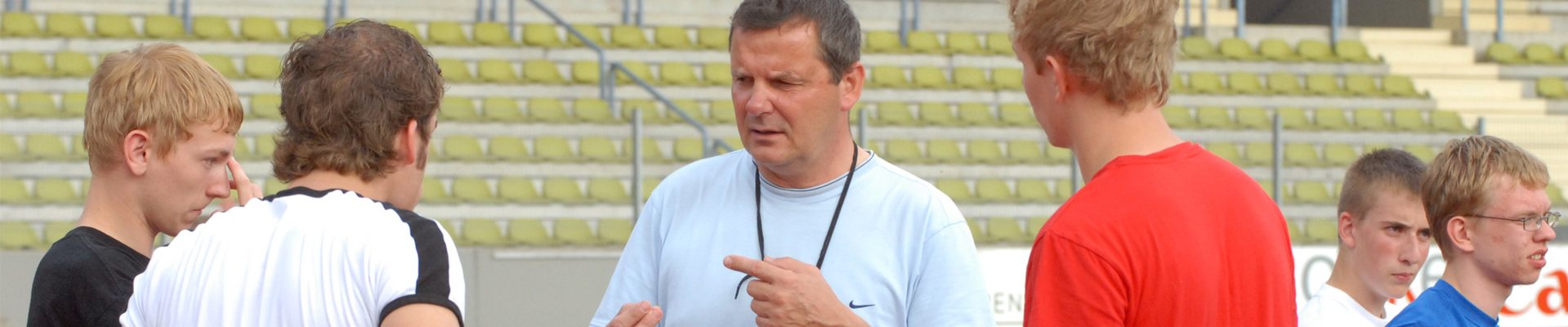 Jungengruppe mit Trainer im Stadion