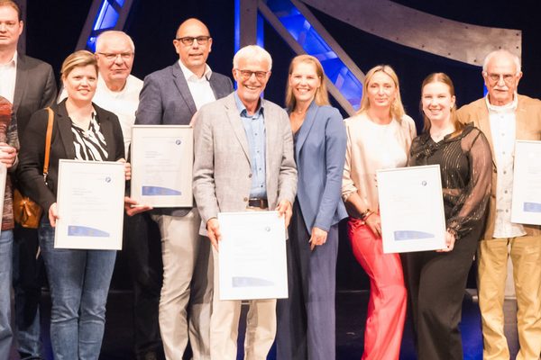 Gewinner auf der Bühne halten Urkunden in der Hand